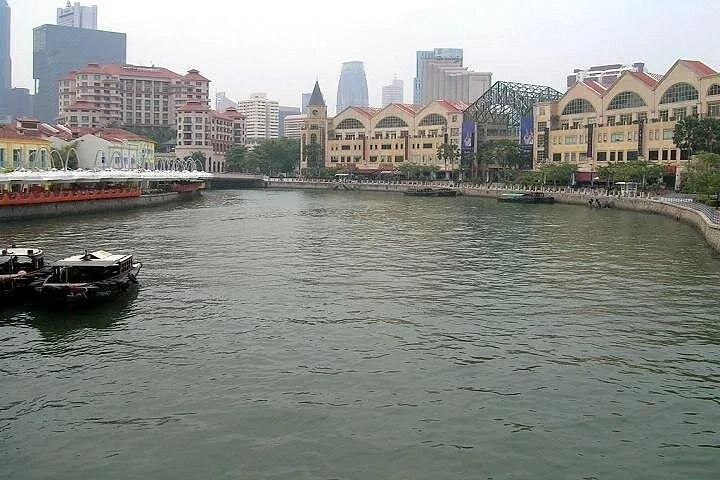 Wide view of Singapore River with boats and city buildings alongside