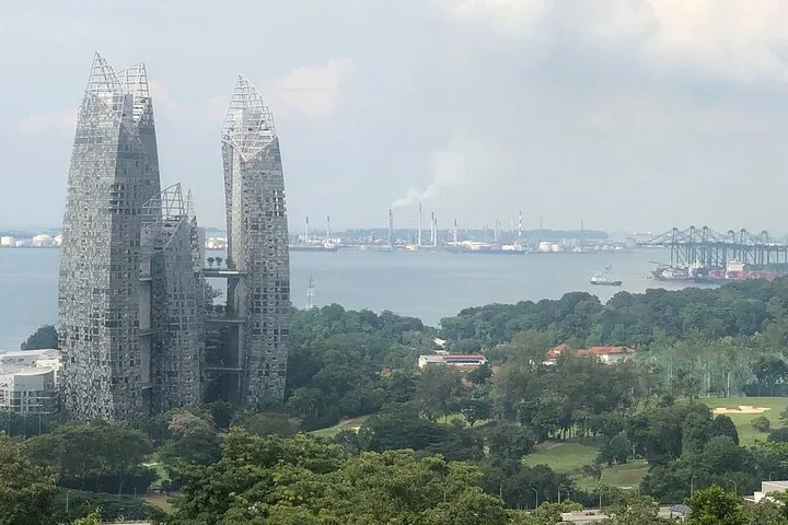 View of modern skyscrapers with industrial area and sea in background
